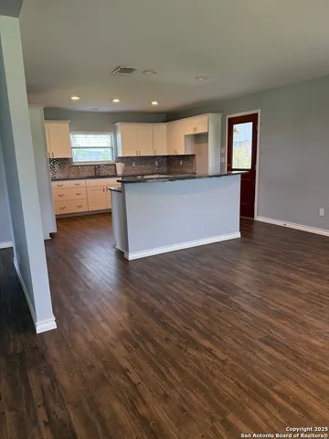 a view of kitchen with granite countertop window and wooden floor