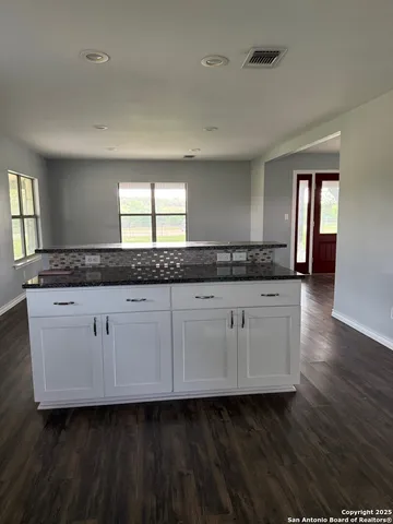a bathroom with a granite countertop sink and a mirror