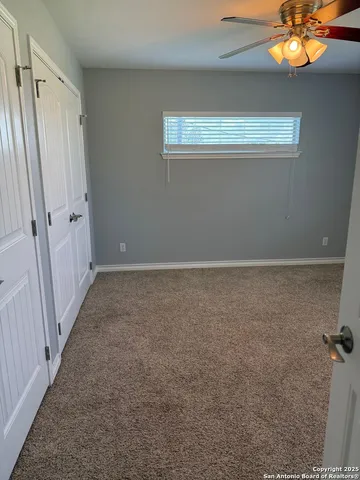 a view of a room with an empty space and a chandelier fan