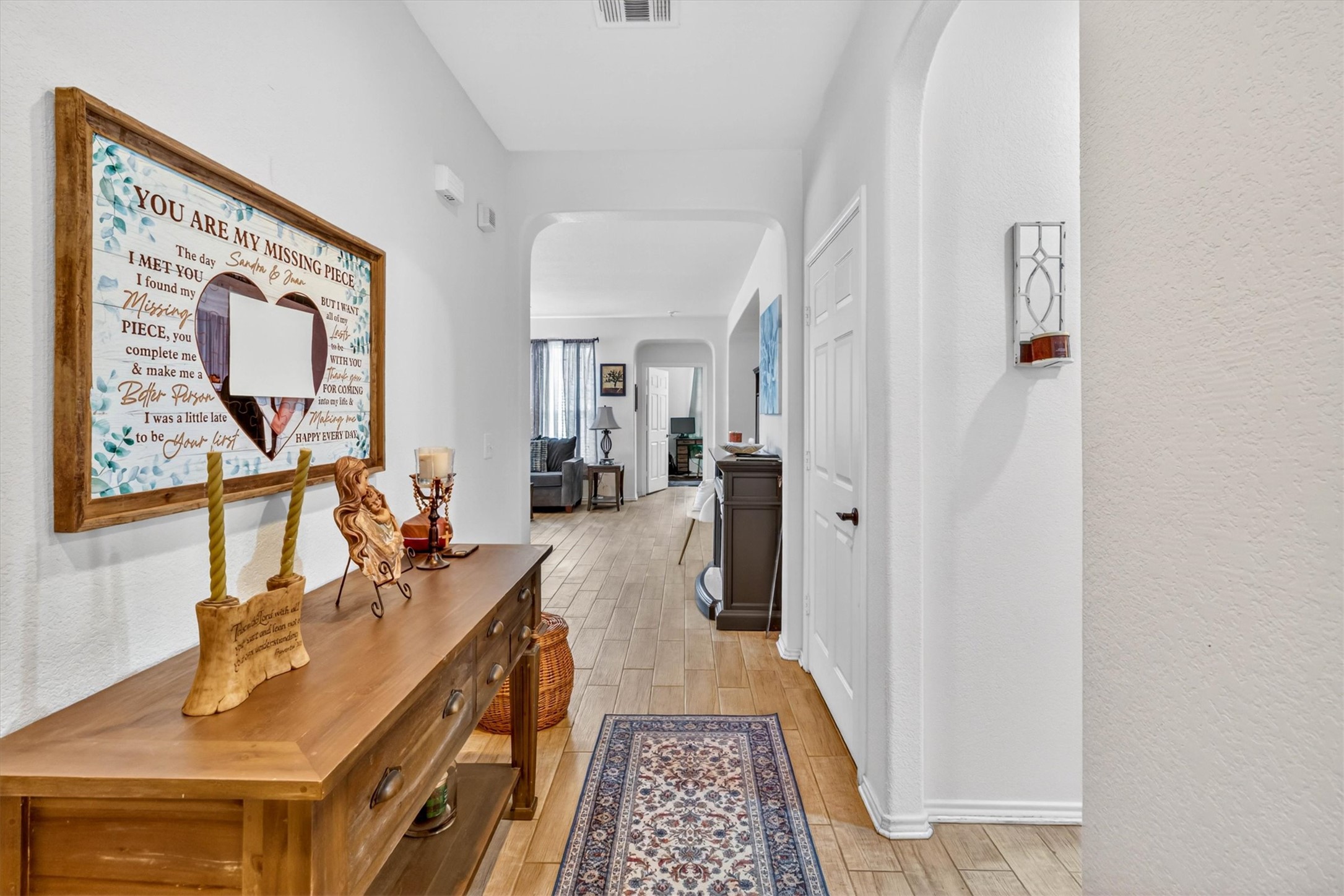 460 Waterleaf Boulevard Kyle, TX 78640 - Photo 6 of 30 Archways and durable wood-look tile flooring create a seamless transition throughout this inviting hallway.