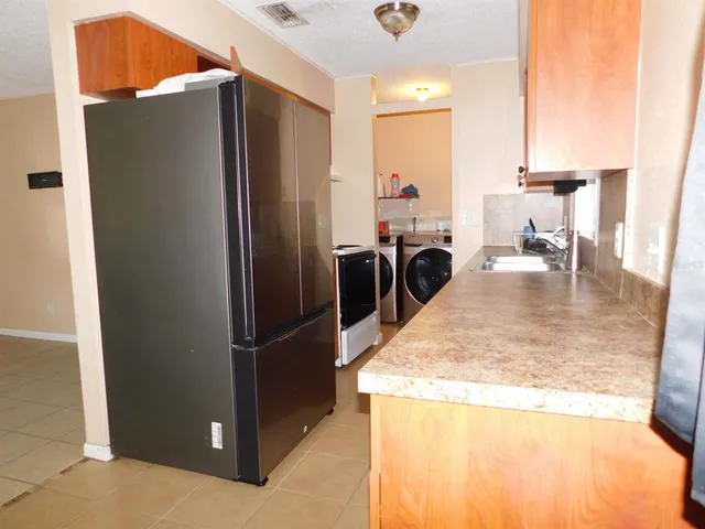 a kitchen with refrigerator and chair
