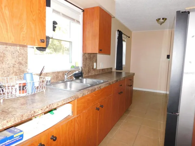a large bathroom with a granite countertop sink and a large mirror next to a window
