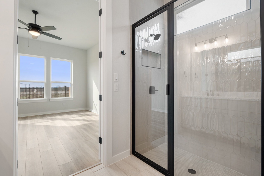 16209 Smithers Road Manor, TX 78653 - Photo 22 of 38 a view of a bathroom with a glass shower door