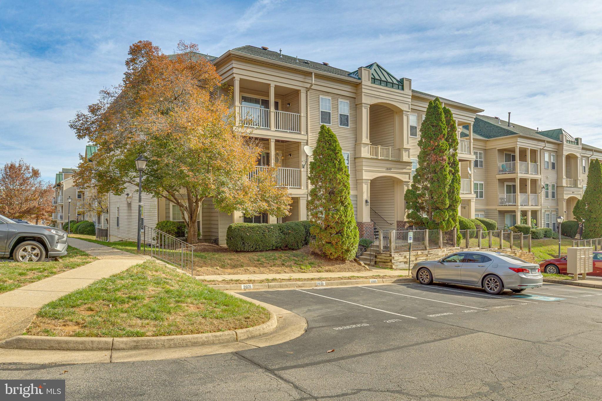 1049 Gardenview Loop, Unit 301 Woodbridge, VA 22191 - Photo 1 of 25 a view of a parked cars in front of a building