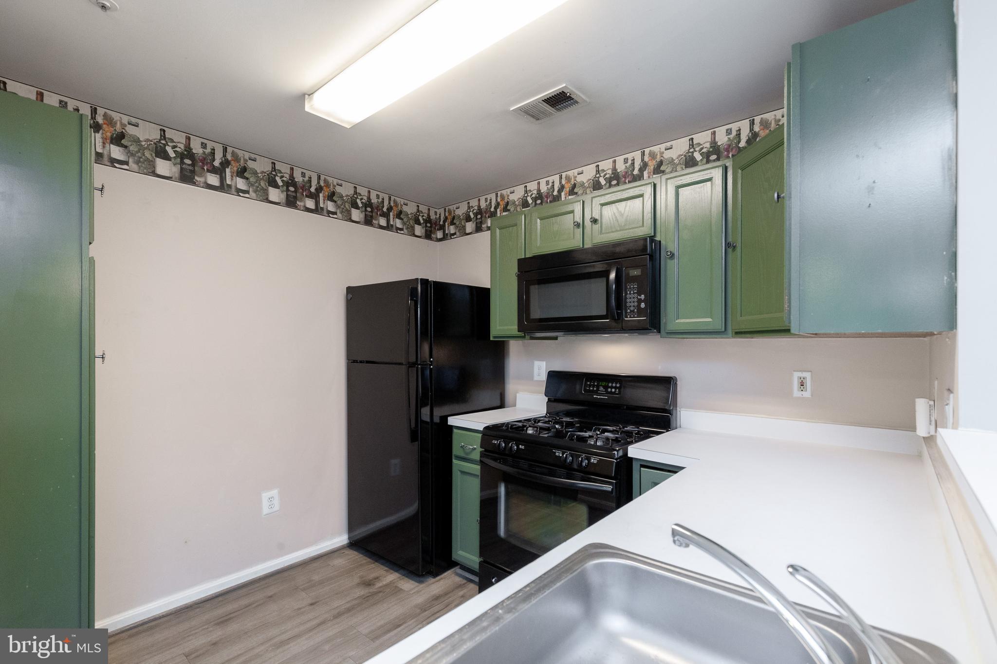 1049 Gardenview Loop, Unit 301 Woodbridge, VA 22191 - Photo 11 of 25 a kitchen with stainless steel appliances a refrigerator and a stove top oven