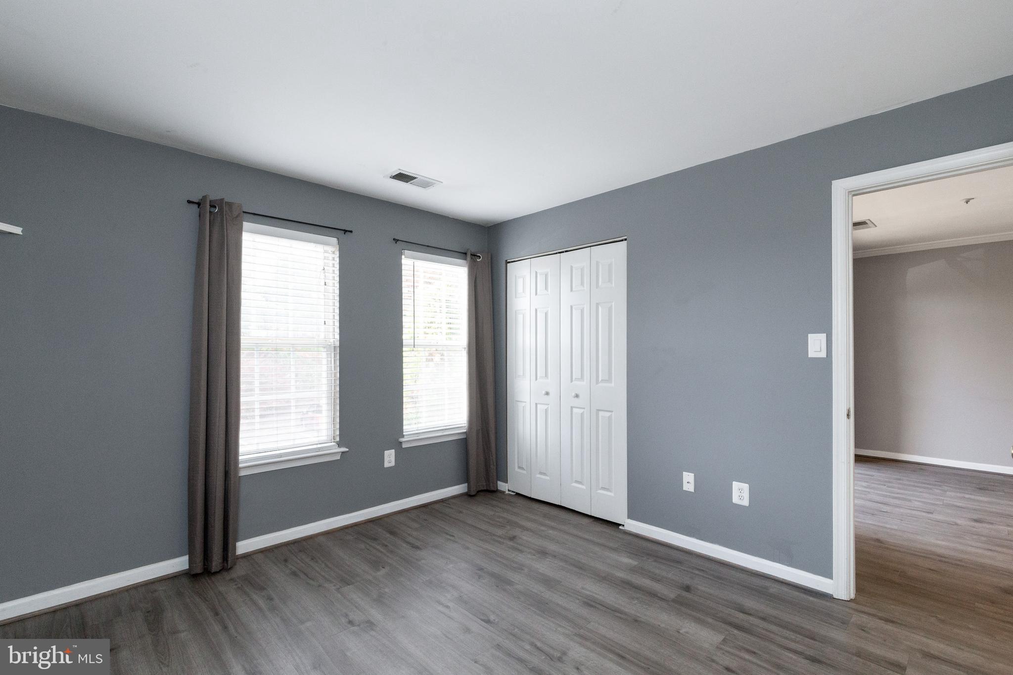 1049 Gardenview Loop, Unit 301 Woodbridge, VA 22191 - Photo 17 of 25 an empty room with wooden floor and windows