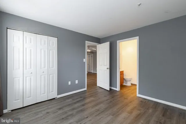 a view of an empty room with closet and a window