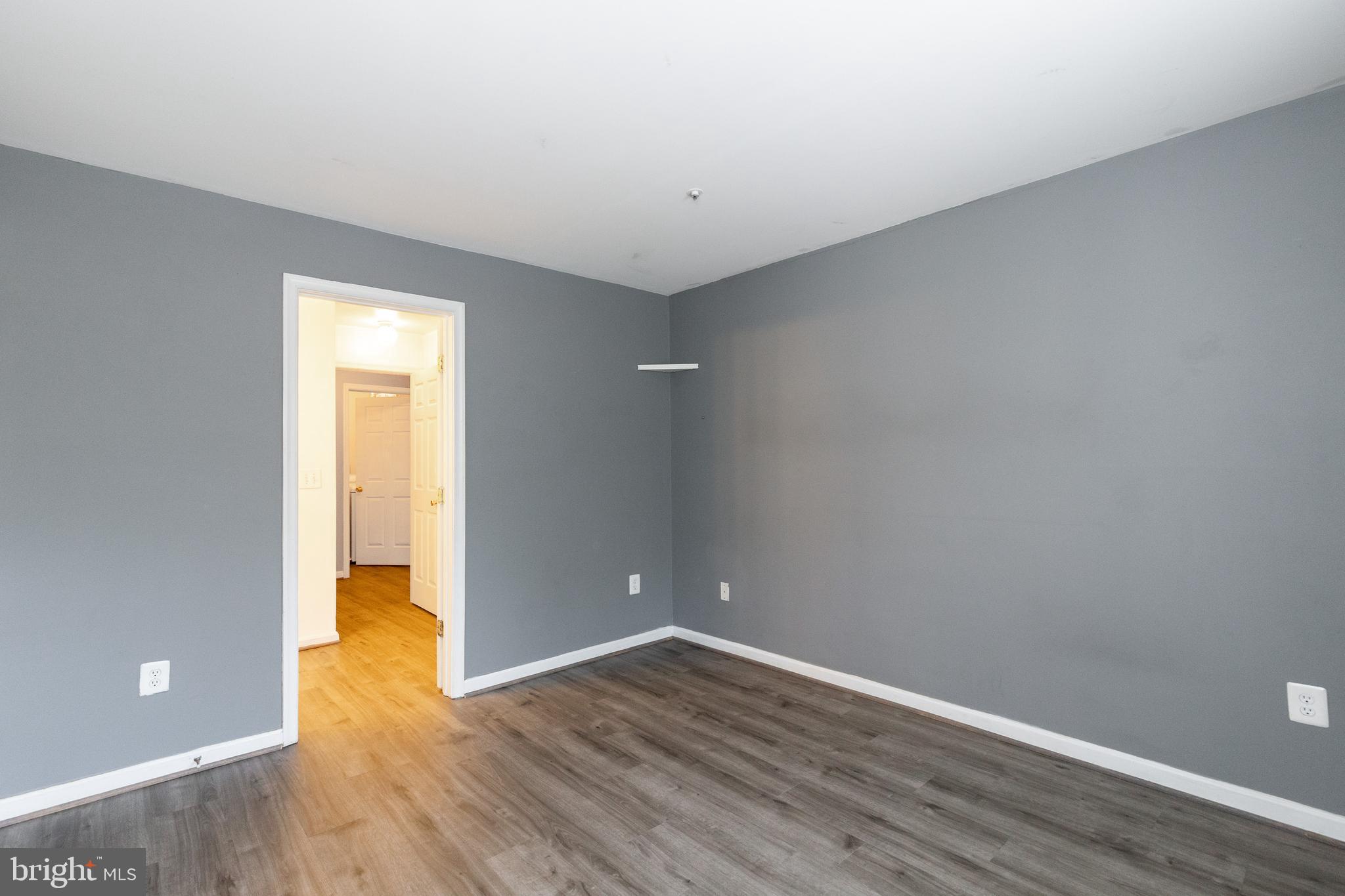 1049 Gardenview Loop, Unit 301 Woodbridge, VA 22191 - Photo 19 of 25 a view of an empty room with wooden floor and a window