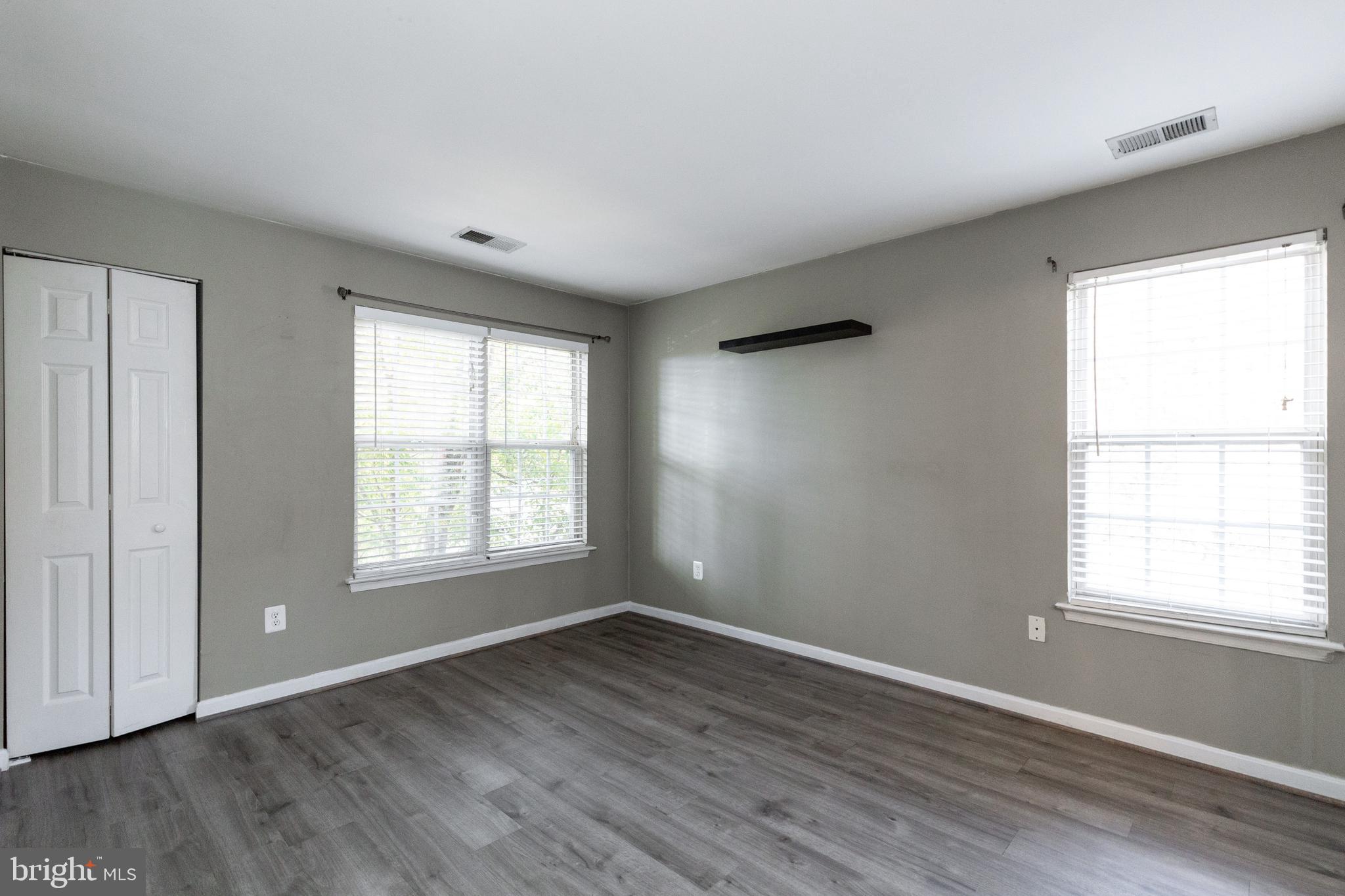 1049 Gardenview Loop, Unit 301 Woodbridge, VA 22191 - Photo 20 of 25 a view of an empty room with wooden floor and a window