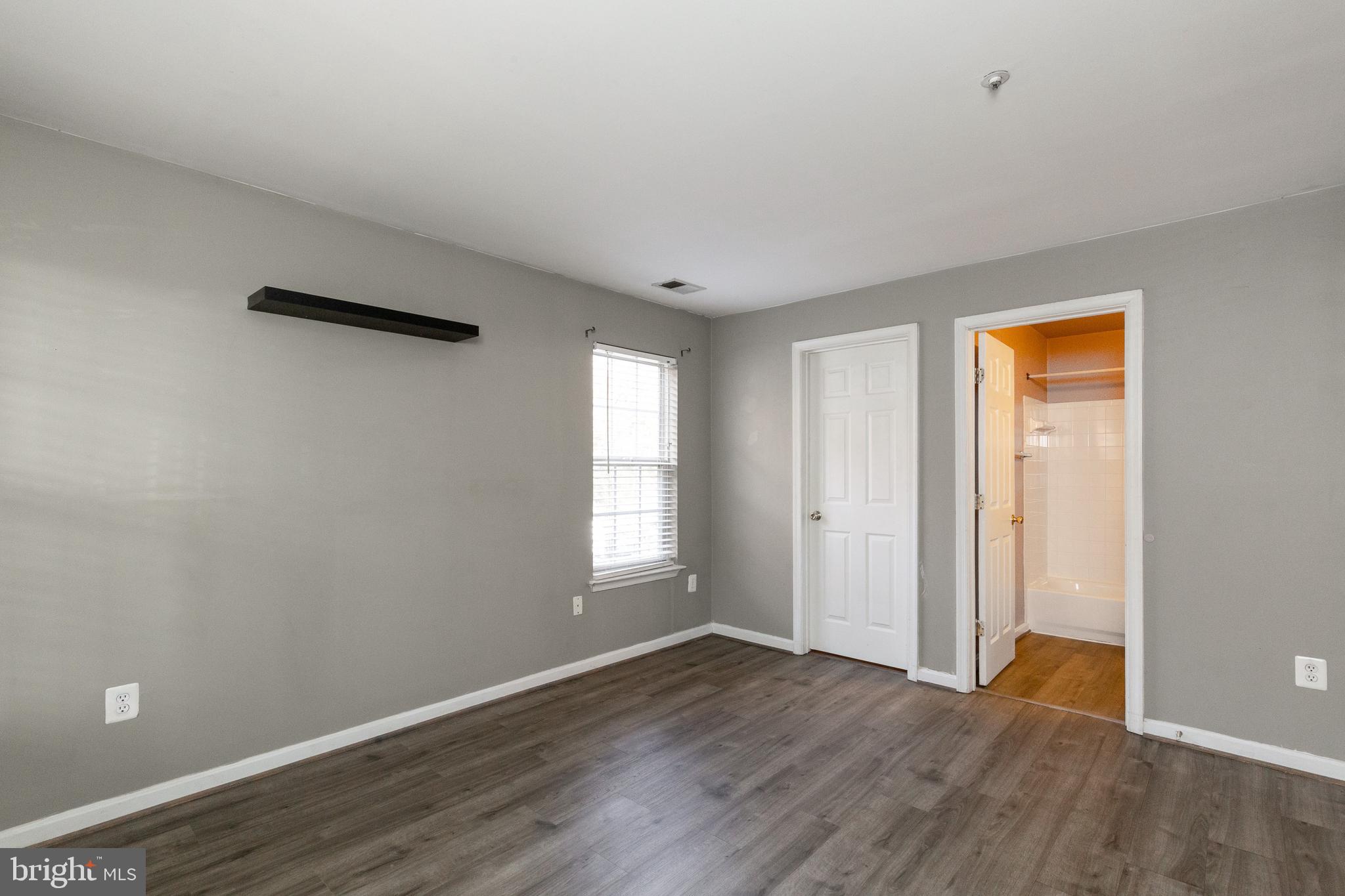 1049 Gardenview Loop, Unit 301 Woodbridge, VA 22191 - Photo 22 of 25 an empty room with wooden floor and windows