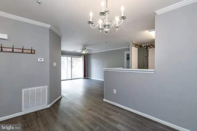 a view of a hallway with wooden floor and chandelier