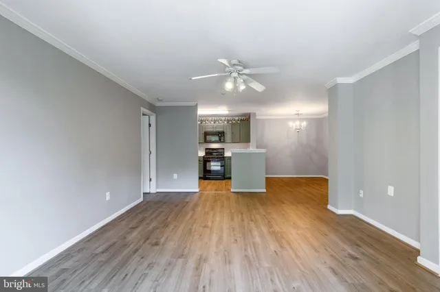 a view of a kitchen with wooden floor and a ceiling fan