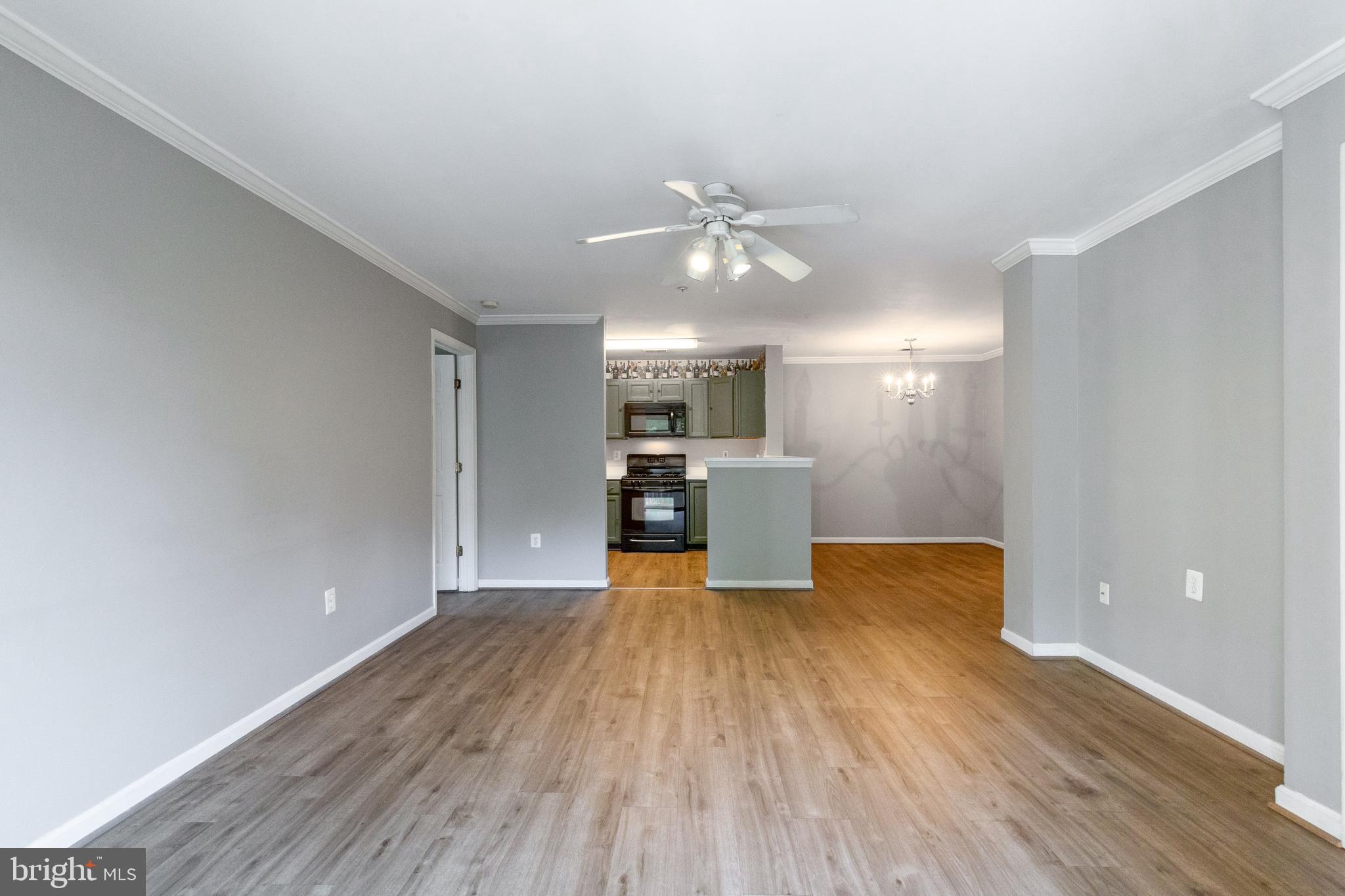 1049 Gardenview Loop, Unit 301 Woodbridge, VA 22191 - Photo 6 of 25 a view of a kitchen with wooden floor and a ceiling fan