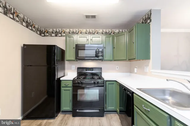 a kitchen with granite countertop a refrigerator and a sink