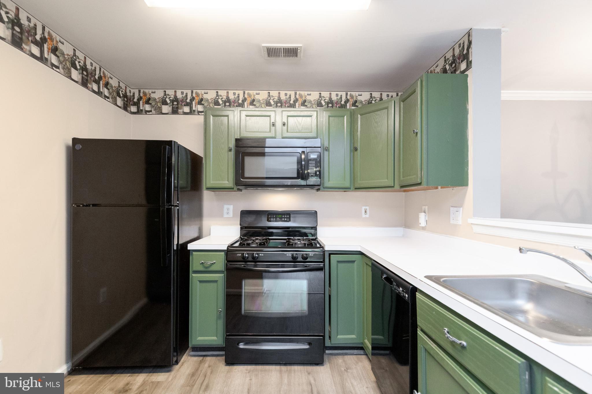 1049 Gardenview Loop, Unit 301 Woodbridge, VA 22191 - Photo 10 of 25 a kitchen with granite countertop a refrigerator and a sink