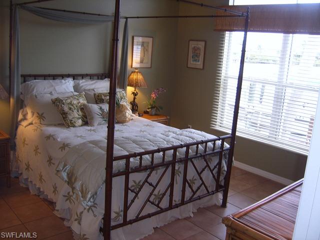 162 Eveningstar Cay Naples, FL 34114 - Photo 4 of 8 a bed sitting in a bedroom next to a window