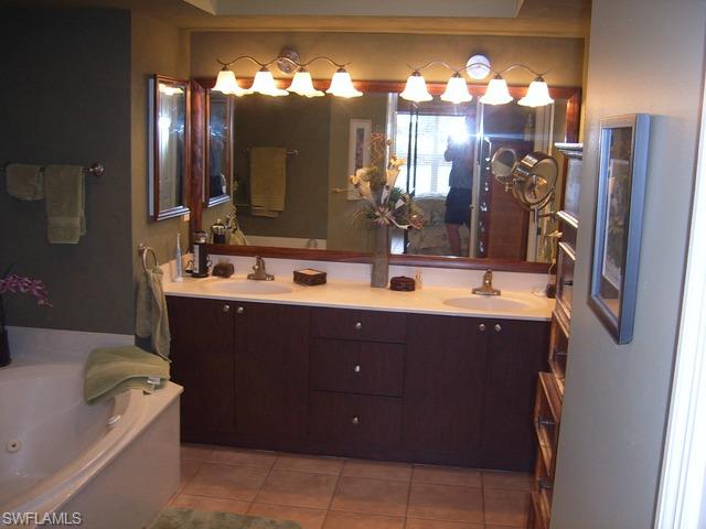 162 Eveningstar Cay Naples, FL 34114 - Photo 5 of 8 a bathroom with a sink vanity and a mirror