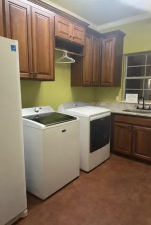 a utility room with sink dryer and washer