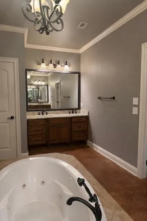 a bathroom with a tub sink and mirror