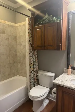 a bathroom with a granite countertop toilet a sink and bathtub