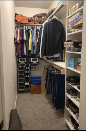 a view of walk in closet with clothes and shoes