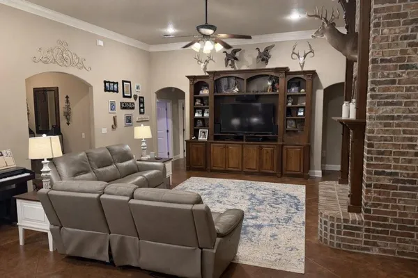 a living room with furniture a chandelier and a flat screen tv