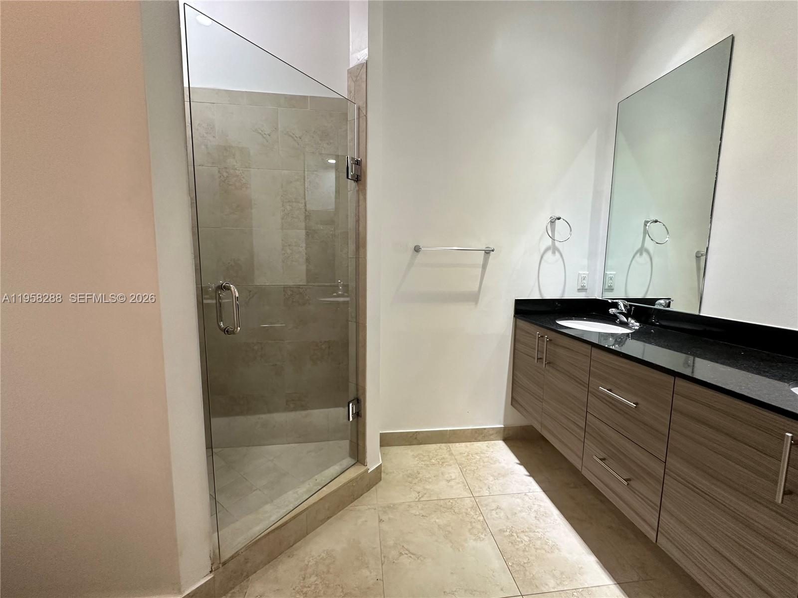 2574 Southwest 81st Terrace, Unit 2564 Miramar, FL 33025 - Photo 14 of 19 a bathroom with a granite countertop sink a mirror and shower