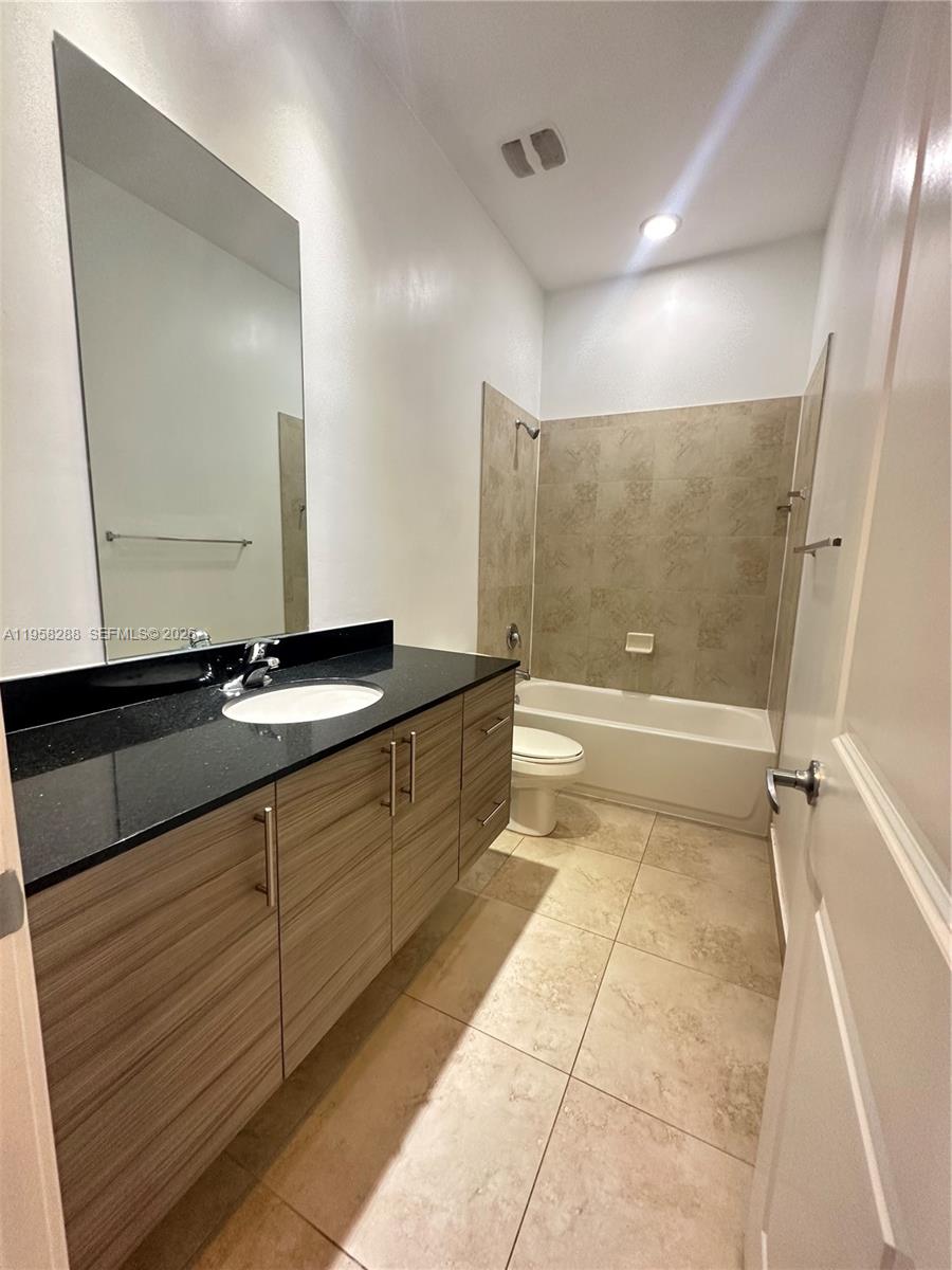 2574 Southwest 81st Terrace, Unit 2564 Miramar, FL 33025 - Photo 17 of 19 a bathroom with a granite countertop sink a mirror and a bathtub