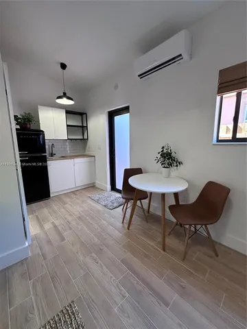 a kitchen with stainless steel appliances wooden floor dining table and chair