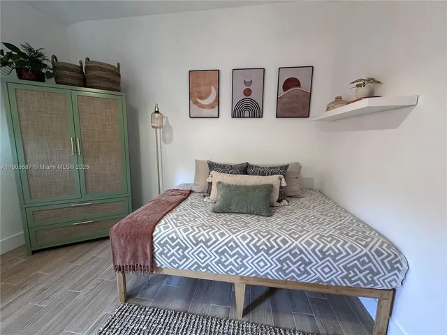a bedroom with a bed and wooden floor