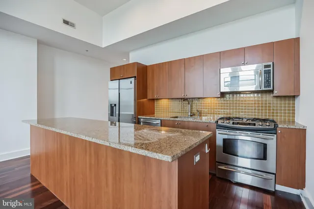 a kitchen with granite countertop a sink stove and refrigerator
