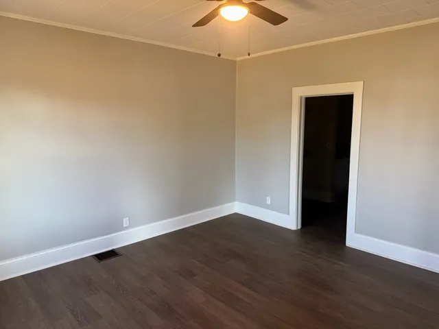 a view of an empty room with wooden floor