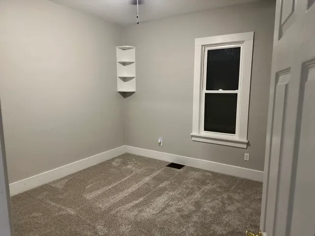 an empty room with windows and closet