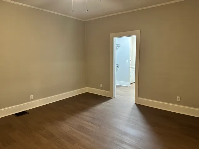 a view of a room with wooden floor and white walls