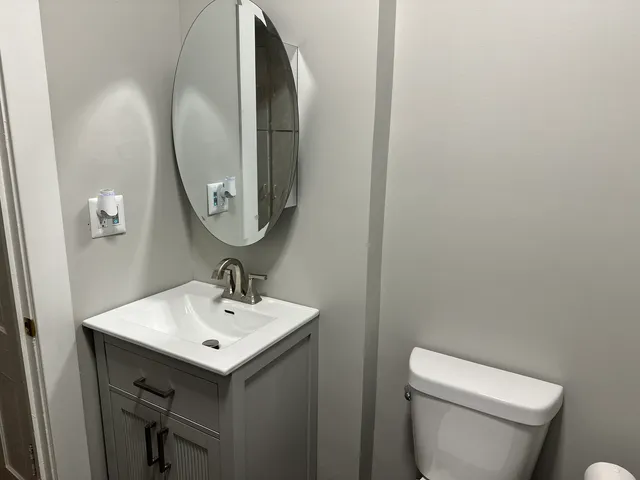 a bathroom with a toilet sink and mirror