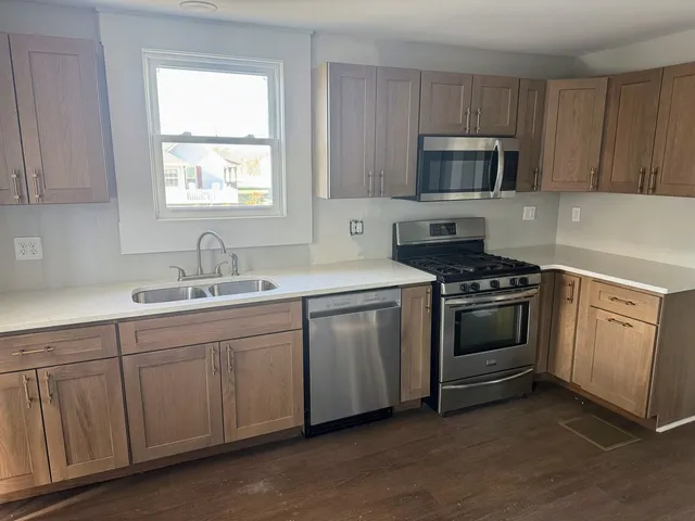 a kitchen with sink a microwave and cabinets