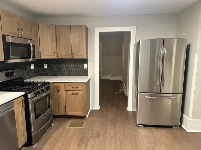 a kitchen with a refrigerator stove and wooden cabinets