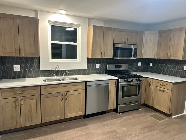 a kitchen with cabinets stainless steel appliances and sink
