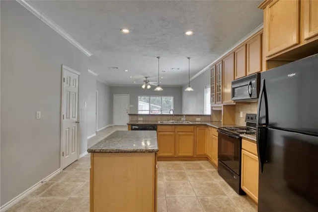a kitchen with stainless steel appliances granite countertop a sink refrigerator and cabinets