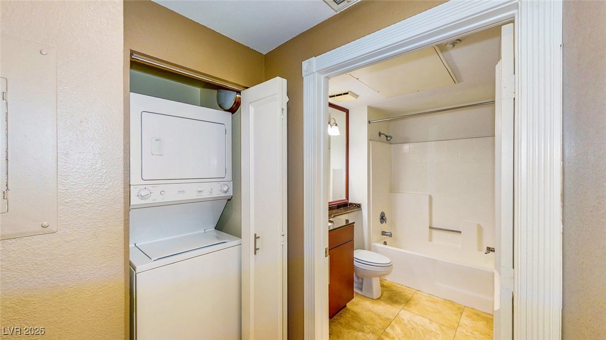 260 East Flamingo Road, Unit 229 Las Vegas, NV 89169 - Photo 14 of 31 Bathroom featuring bathtub / shower combination, vanity, a textured wall, stacked washer and clothes dryer, and electric panel