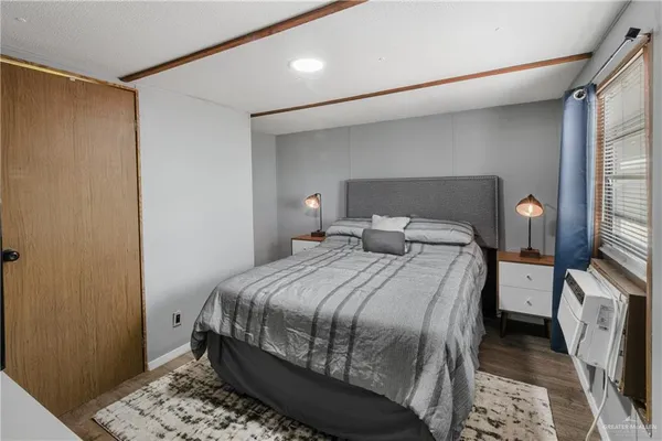 a bedroom with a bed and wooden floor