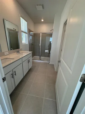 a bathroom with a double vanity sink toilet and mirror