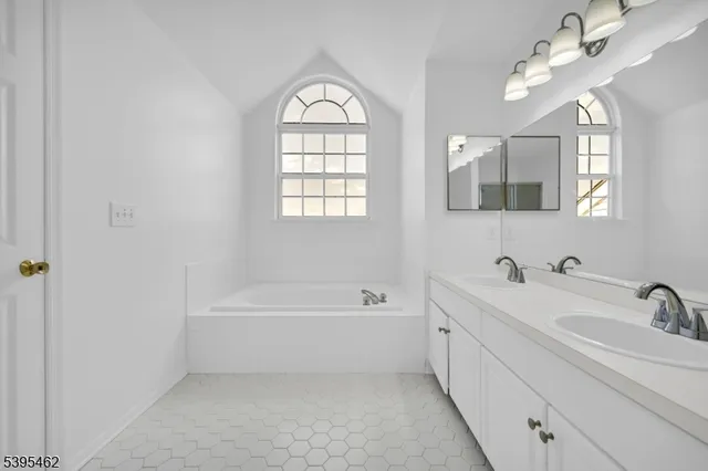 a bathroom with a bathtub a sink and mirror