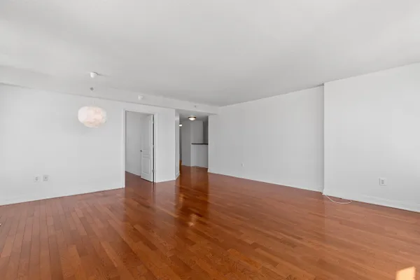 a view of an empty room with wooden floor