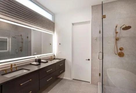 a bathroom with a granite countertop sink mirror and shower