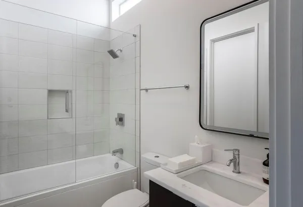 a bathroom with a granite countertop sink toilet and shower
