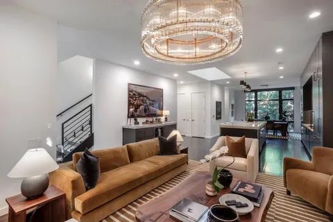 a living room with furniture and a chandelier