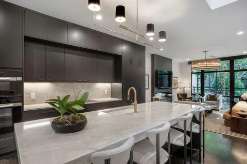 a kitchen with a table a potted plant and chairs