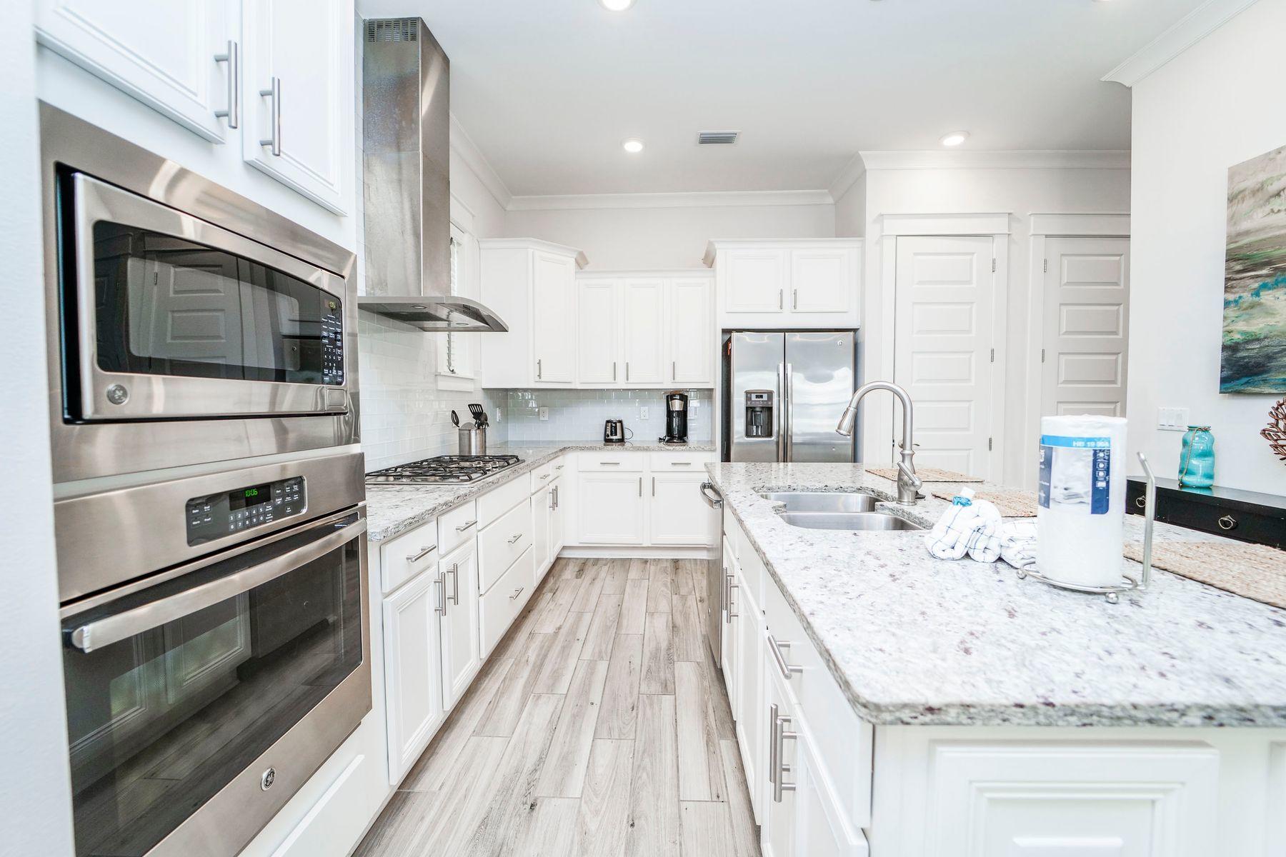58 York Ln Inlet Beach, Unit B Inlet Beach, FL 32461 - Photo 6 of 24 a large kitchen with stainless steel appliances kitchen island granite countertop a stove and a sink with cabinets