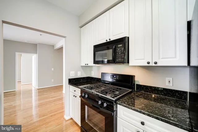 a kitchen with granite countertop stainless steel appliances a stove a microwave and cabinets